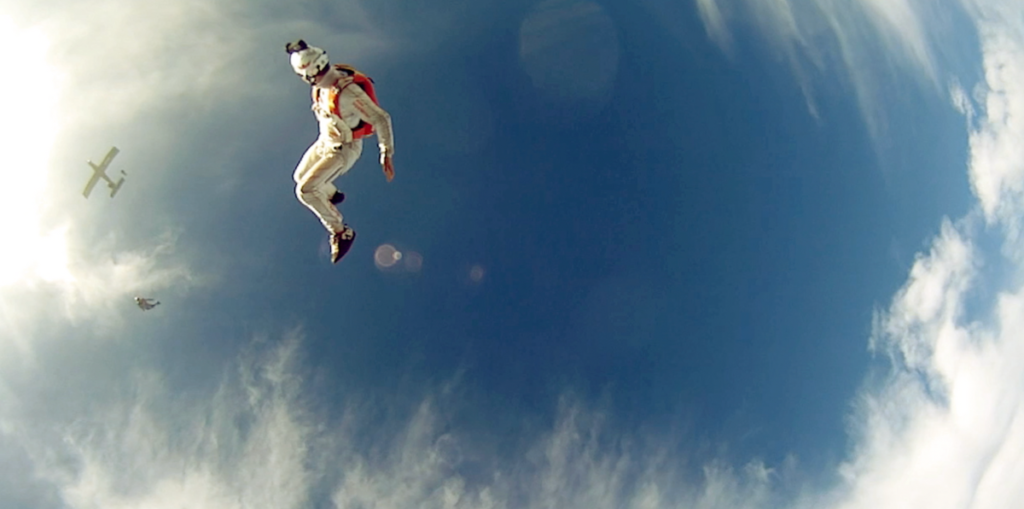 Solo skydiver watching friends jump from plane